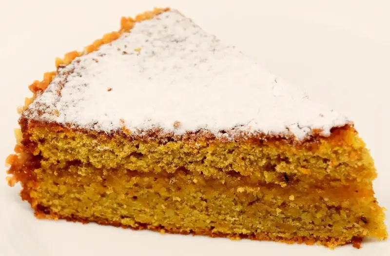 Wilgotne ciasto marchewkowe posypane cukrem pudrem. Idealne na deser, choć warto sprawdzić ciasto marchewkowe kcal przed zjedzeniem.