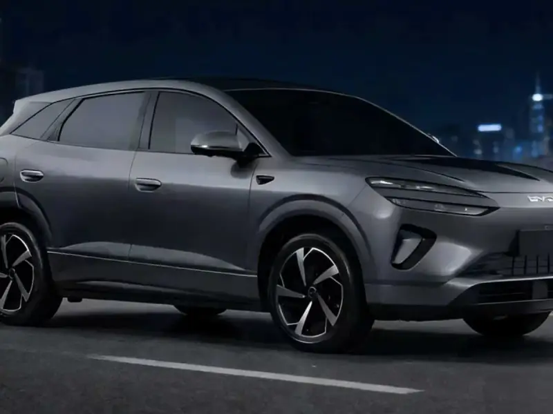 Szary samochód elektryczny BYD na tle nocnego miasta.