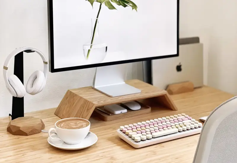 Un café latte, un clavier pastel et un casque blanc composent ce setup bureau idéal pour travailler avec style.