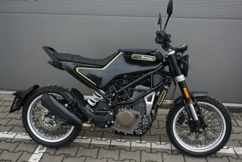 Czarny motocykl Husqvarna Svartpilen 401 z żółtymi akcentami, gotowy na miejskie przygody.