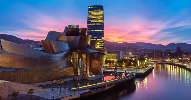 Zachód słońca nad rzeką w Euskadi, z Muzeum Guggenheima i wieżowcem Iberdrola w tle.