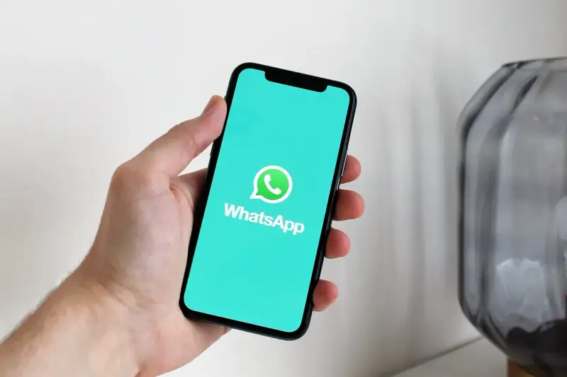 Dłoń trzyma smartfon z logo WhatsApp. Idealne narzędzie do komunikacji, gdy masz internet za granicą.