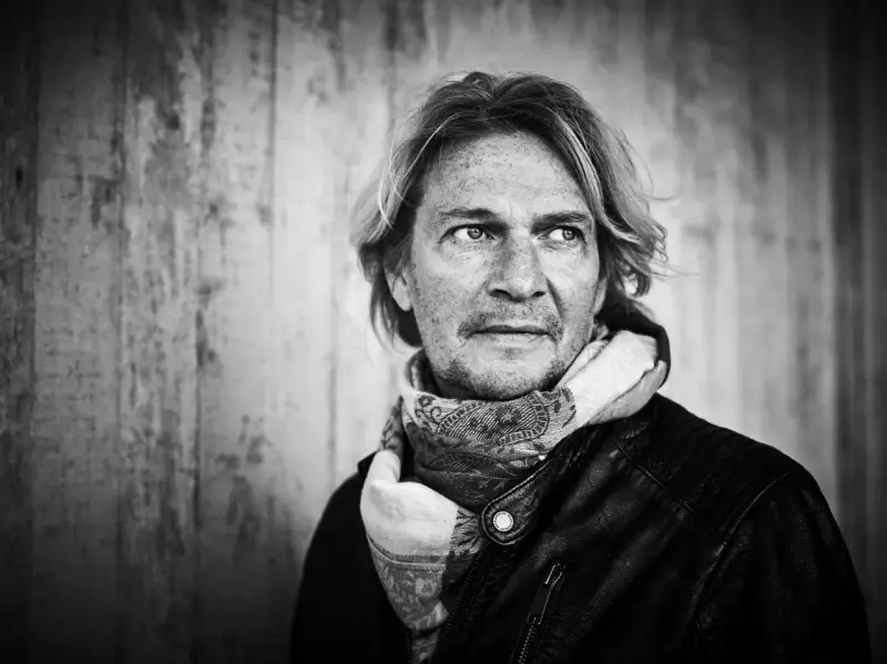 Tommy Nilsson, med sitt karaktäristiska utseende och en scarf, redo att inta scenen med sitt band.