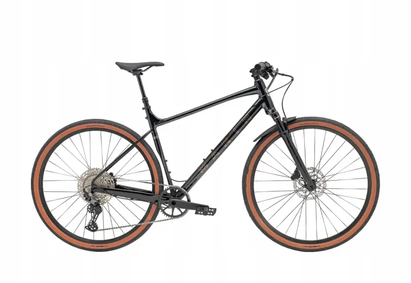 Czarny rower gravel z prostą kierownicą, brązowymi oponami i błotnikami. Idealny na przygody po szutrowych drogach.