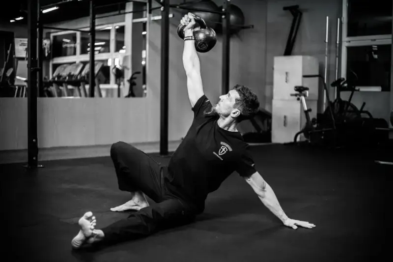 Mężczyzna wykonuje ćwiczenia na siłowni z kettlebell.