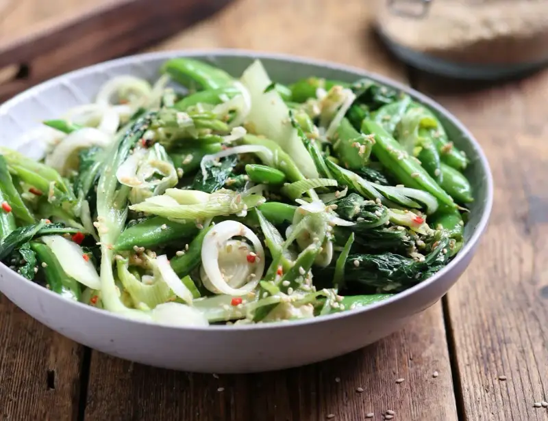 Zielona sałatka z pak choi, groszku cukrowego i cebuli, posypana sezamem. Idealna do dań kuchni azjatyckiej, świetne kapusta pak choi przepisy.