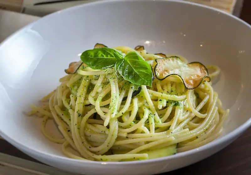 Spaghetti alla Nerano con calabacín y albahaca en un cuenco blanco.