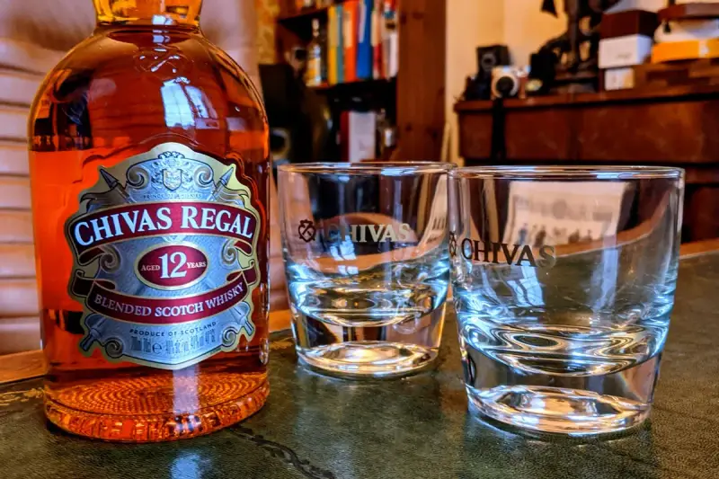 Chivas Regal 12 z czym pić? Butelka Chivas Regal 12 i dwa kieliszki, gotowe na degustację.
