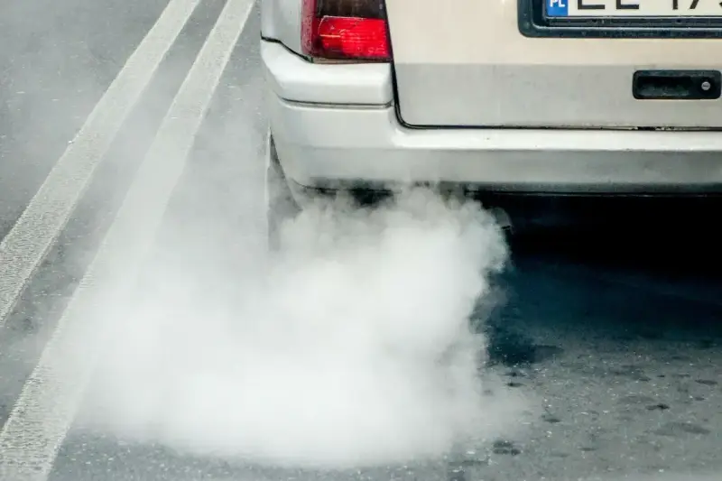 Z tyłu samochodu wydobywa się biały dym. Widać fragment tylnej lampy i tablicy rejestracyjnej. Diesel kopci na biało.