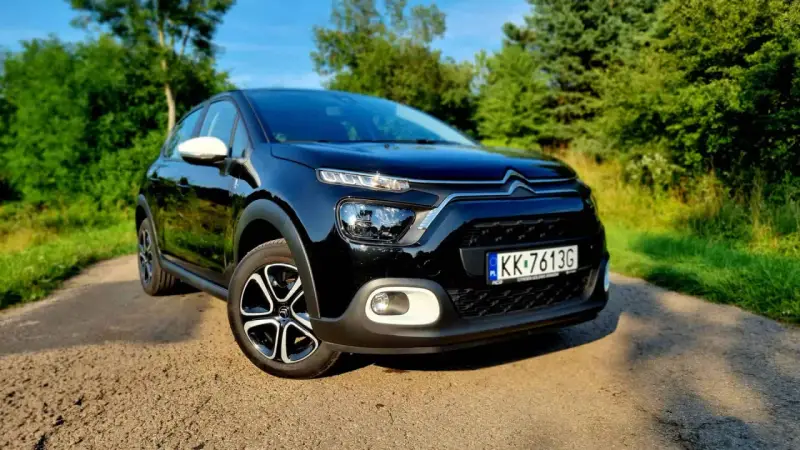 Czarny Citroen C3 na tle zieleni. Sprawdź atrakcyjną citroen c3 cena i wybierz swój wymarzony samochód.
