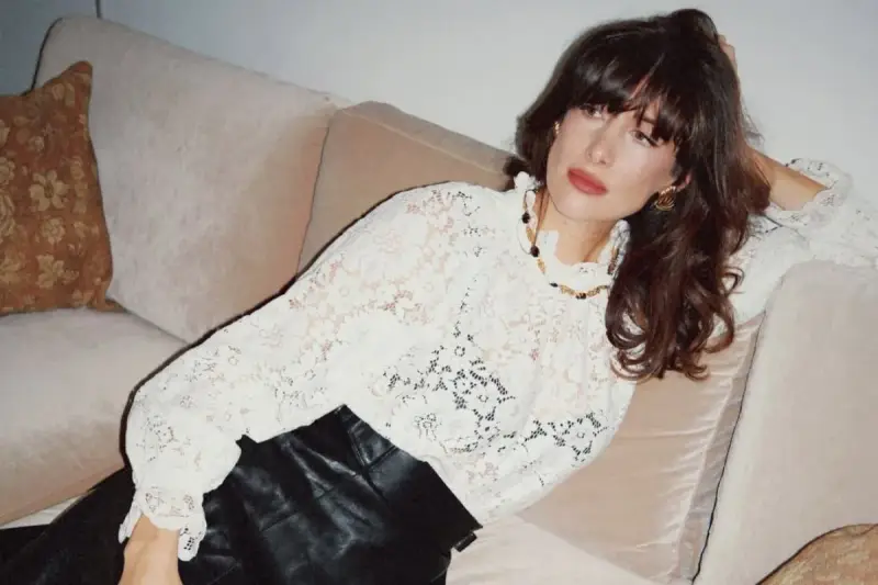 Kobieta w koronkowej bluzce i skórzanych spodniach, uosobienie stylu boho stylizacje.