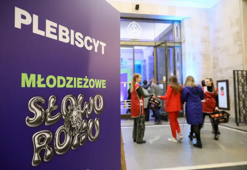 Plakat "PLEBISCYT Młodzieżowe Słowo Roku" z lwem w koronie. W tle młodzież wchodzi do budynku.