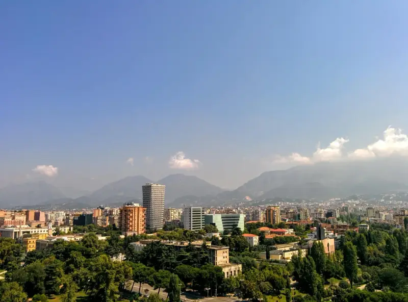 Widok na Tiranę, Albanię. Miasto z nowoczesnymi budynkami i górami w tle. Czy w Albanii jest bezpiecznie? Tak, podróżni często czują się tu bezpiecznie.