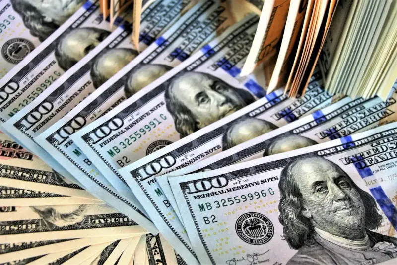 Stos banknotów 100-dolarowych, symbolizujących zabezpieczenie majątkowe w postępowaniu karnym.