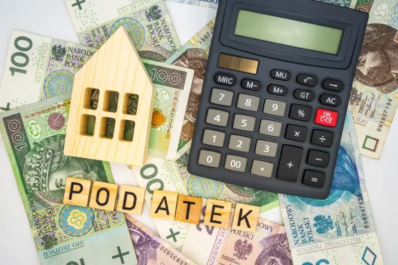 Drewniany domek, kalkulator i polskie banknoty. Czy podatek od nieruchomości za grunt wzrośnie o maksymalną stawkę 4,5 procent?