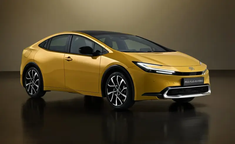 Złoty Toyota Prius Plug-in Hybrid, kiedy nowy prius w polsce, prezentuje się nowocześnie z czarnym dachem i eleganckimi felgami.