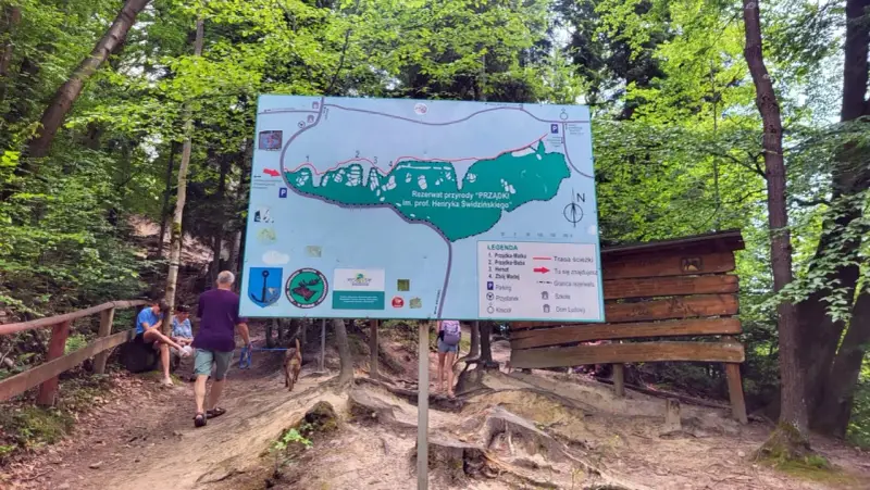 Mapa szlaku w rezerwacie przyrody "Prządki" im. prof. Henryka Świdzińskiego. Turyści z psem zwiedzają malowniczą okolicę.