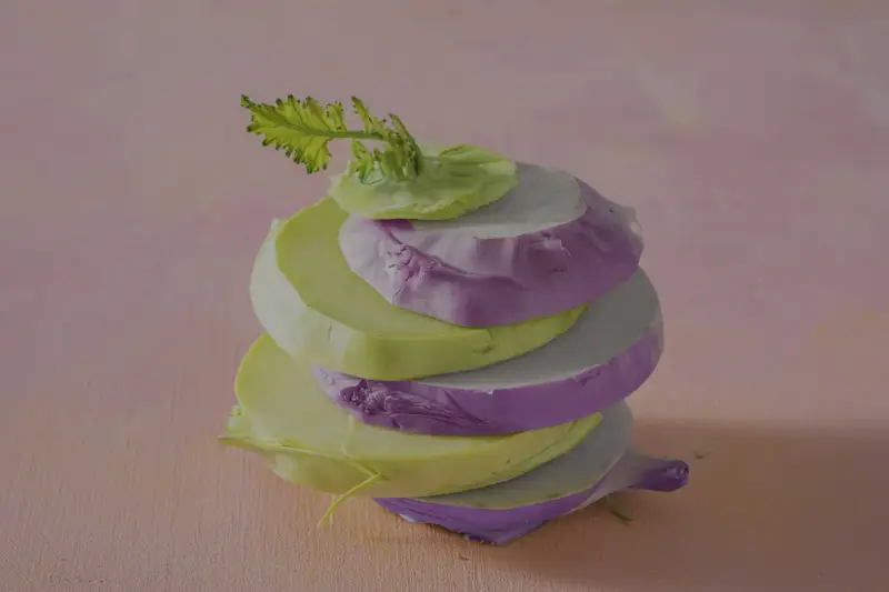 Gestapelte Scheiben von grünem und violettem Kohlrabi, bereit zum Kohlrabi kochen.