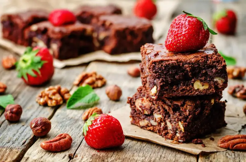 Czekoladowe brownie z orzechami i truskawkami. Pyszna przekąska, której brownie kcal nie zrujnuje diety.