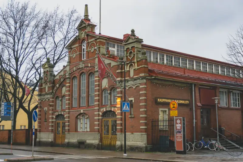 Targowisko Kauppahalli w Turku, najstarszym mieście w Finlandii, z charakterystyczną ceglaną fasadą i czerwonym dachem.