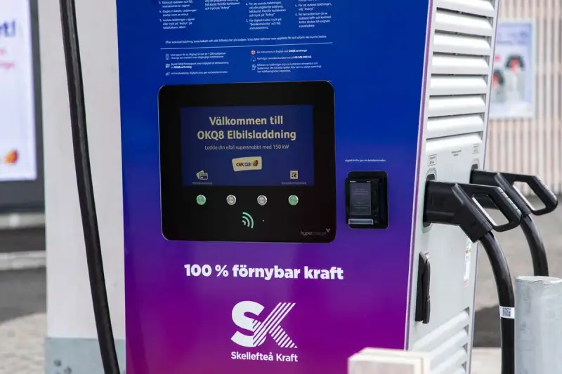 OKQ8 electric car charging station with two charging cables and a screen displaying "Welcome to OKQ8 Electric Charging".