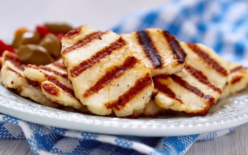 Grillowany ser halloumi na talerzu, z widocznymi paskami z grilla. Idealny dodatek do sałatek, z niską zawartością halloumi kcal.