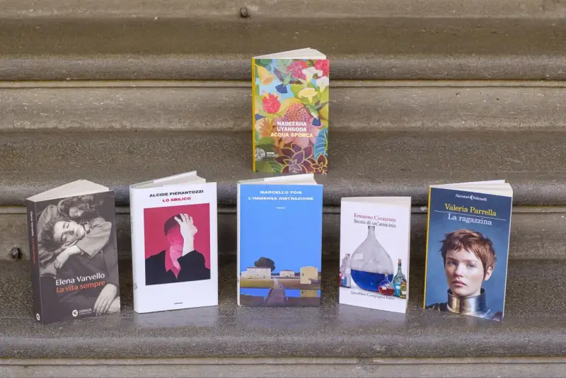 Libri in mostra, tra cui "La vita sempre" e "La ragazzina", candidati ai premi letterari più importanti.