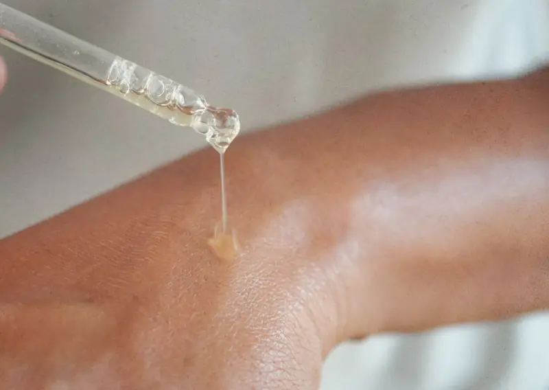 Kropla serum z niacynamidem 5% spada na skórę, nawilżając ją i odżywiając.