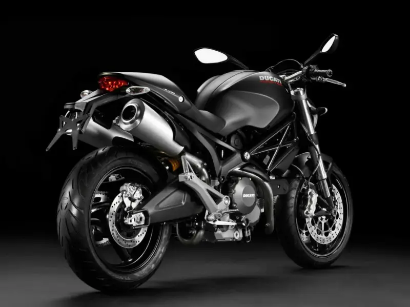 Czarny Ducati Monster 696 z podwójnym wydechem i sportowym wyglądem, gotowy do jazdy.