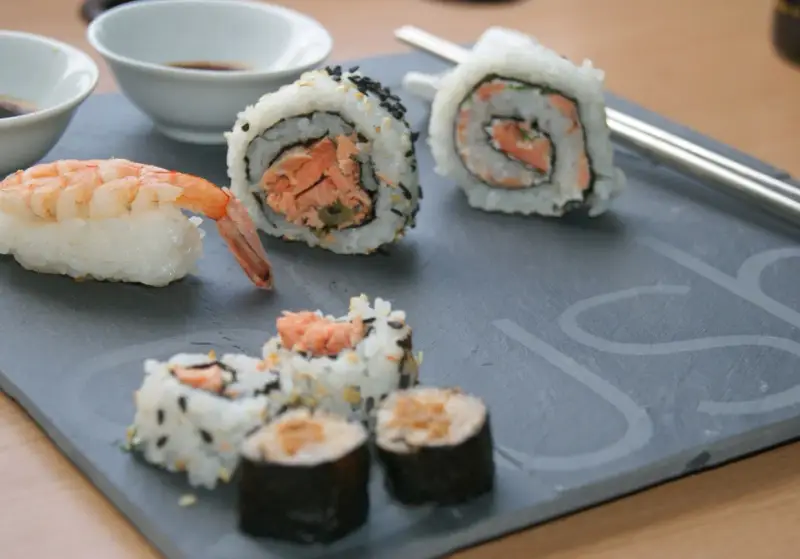 Jak przygotować krewetki do sushi? Na talerzu sushi z krewetką i rolkami z łososiem.