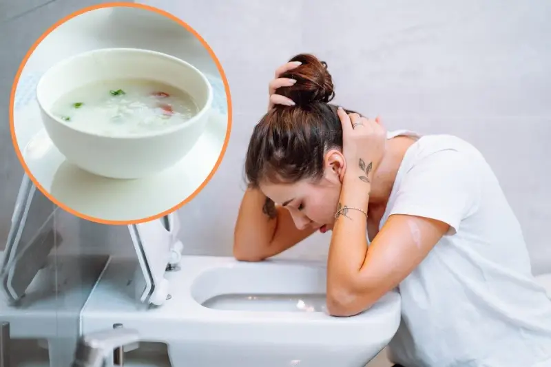 Kobieta z zatruciem pokarmowym pochyla się nad toaletą. W rogu widać miseczkę z ryżem i warzywami.