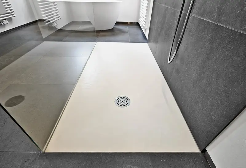 Receveur de douche blanc, quelle matière choisir pour un style moderne ? Sol gris, paroi sombre.