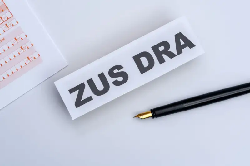 ZUS DRA na papierze, obok czarne pióro. Dokumenty do wypełnienia.