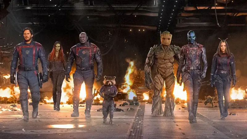 Strażnicy Galaktyki: Volume 3 obsada – Star-Lord, Gamora, Drax, Rocket, Groot, Nebula i Mantis idą przez płonące ruiny.