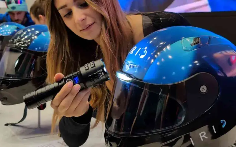 Donna mostra un casco da moto blu con visiera, evidenziando la sua importanza per la sicurezza. È bene che il casco sia dotato di visiera.