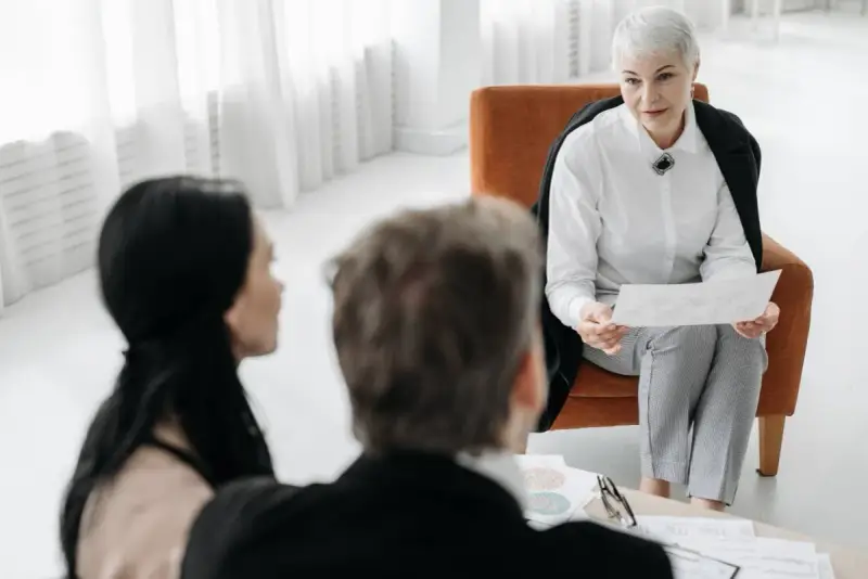 Pracownik socjalny omawia dokumenty z parą.