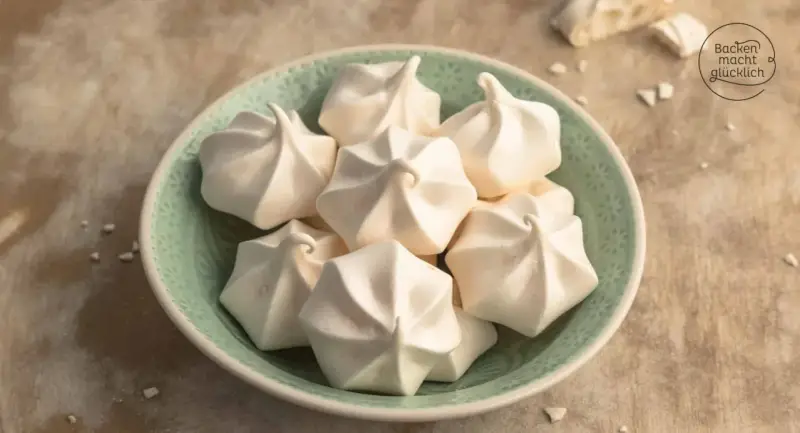Ein Teller voller zarter Baiser, perfekt für jedes Baiser Rezept. Sie sehen aus, als wären sie frisch aus dem Ofen und bereit, auf der Zunge zu zergehen.