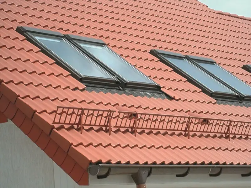Nowy dach z dachówką ceramiczną, orynnowanie i okna dachowe zapewniające światło.