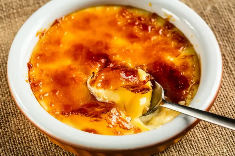 Crème brûlée, un dessert iconique dont l'origine remonte au XVIIe siècle, avec sa croûte caramélisée craquante et sa crème onctueuse.