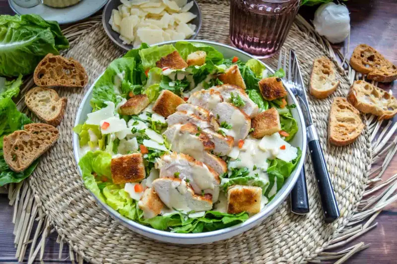 Saftiges Hähnchenbrustfilet auf knackigem Römersalat mit Croutons und cremiger Sauce – eine köstliche Caesar Salad.