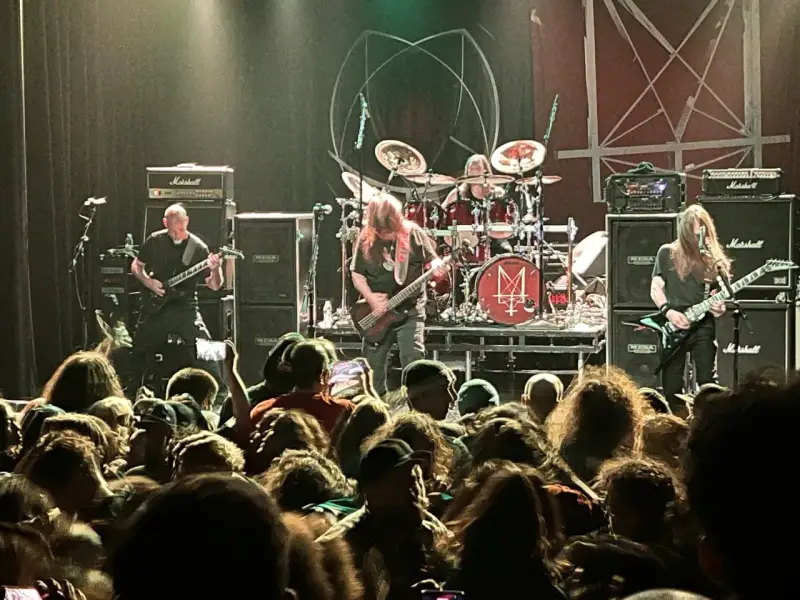 Concert de metal, musiciens sur scène, foule en délire. Le groupe semble prêt à envoyer du lourd, un vrai voyage ad patres pour les fans.