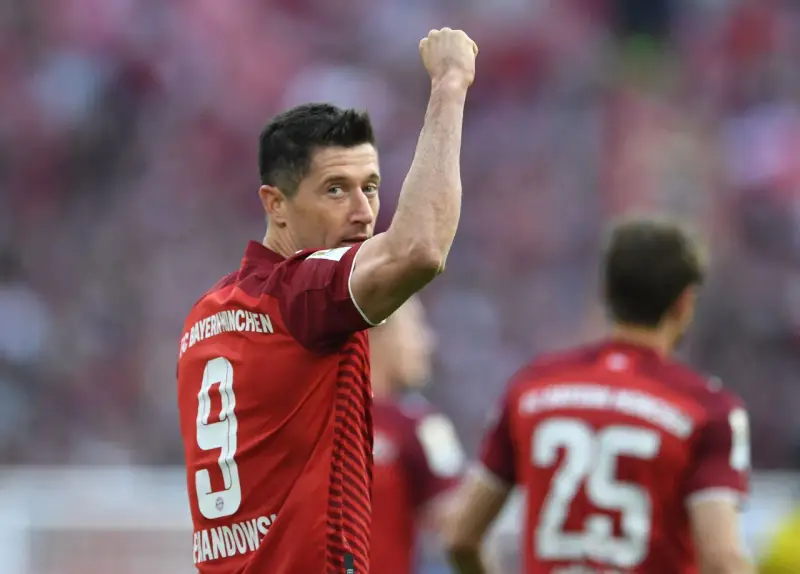 Piłkarz Robert Lewandowski w czerwonej koszulce z numerem 9 świętuje bramkę.