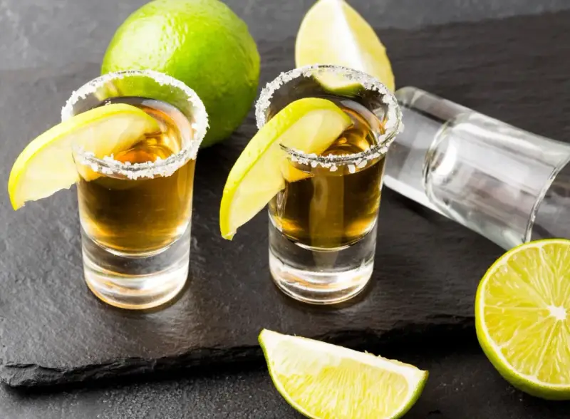 Dwa kieliszki tequili z solą i limonką, gotowe do degustacji. Czas sprawdzić, jak smakuje tequila!