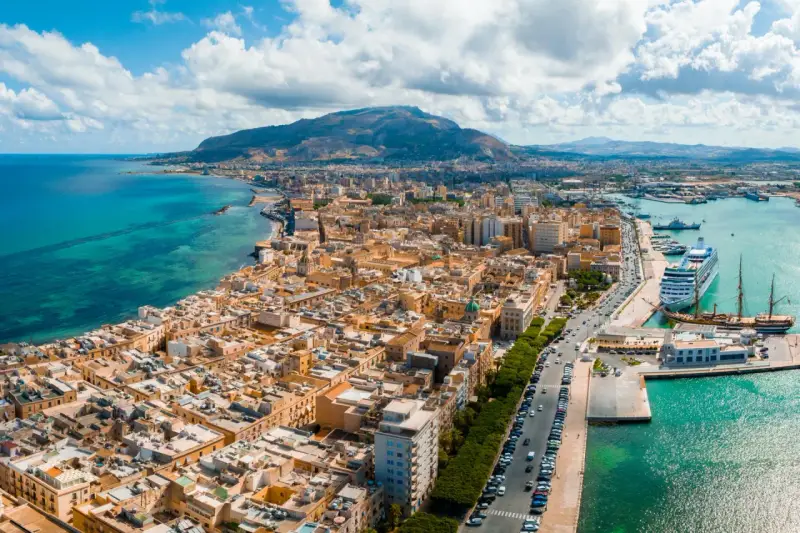 Widok na Trapani, Sycylia. Miasto z widokiem na turkusowe morze i góry. Zobacz, co warto zobaczyć w Trapani: port z luksusowym rejsem i zabytkowymi żaglowcami.