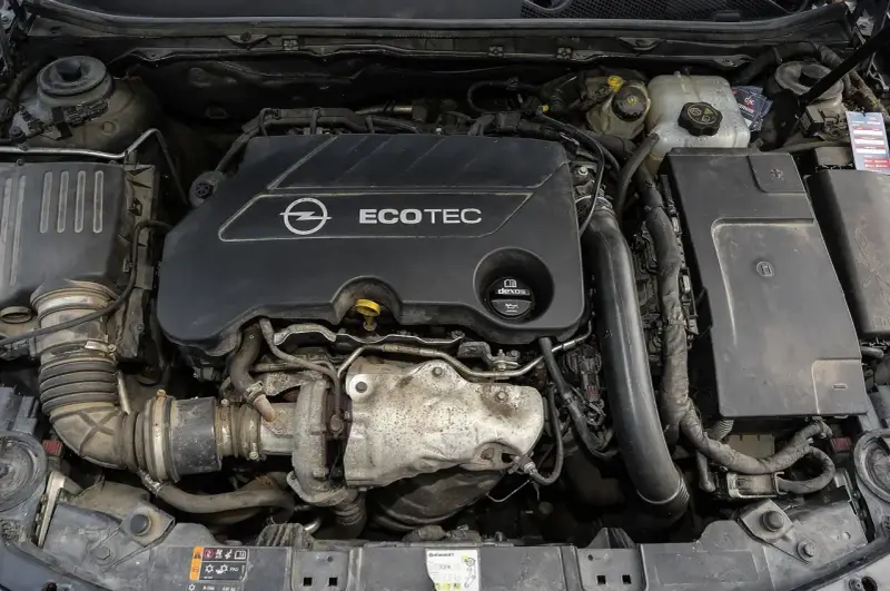 Silnik Opel Ecotec. Widoczne elementy układu dolotowego i turbosprężarki. Objawy uszkodzenia poduszki silnika mogą być różne, np. wibracje.
