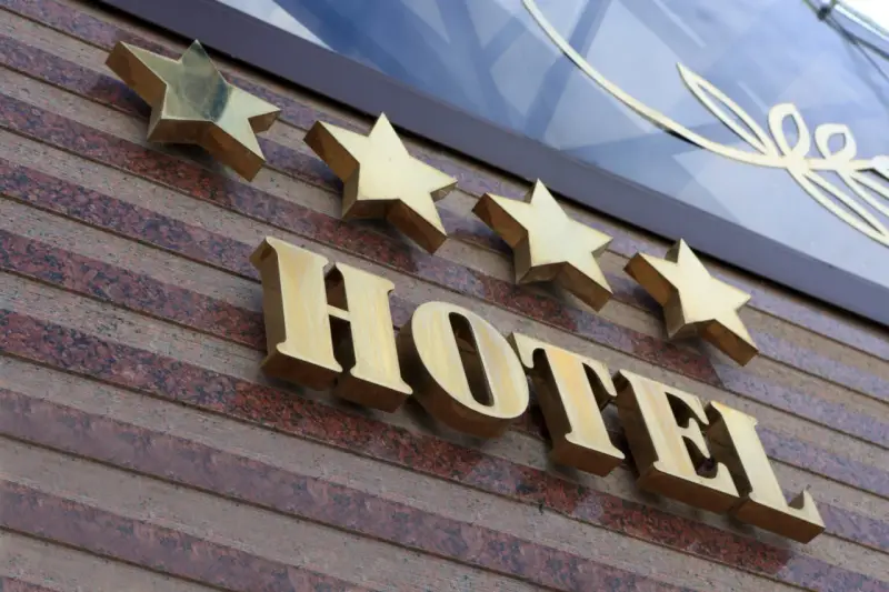 Złote gwiazdki nad napisem HOTEL. To one decydują, kto nadaje gwiazdki hotelom, wskazując na jego standard.