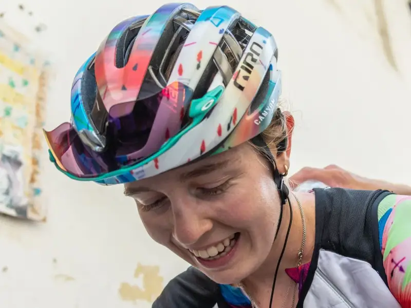 Lachende Antonia Niedermaier mit buntem Helm und Brille, bereit für das nächste Rennen.