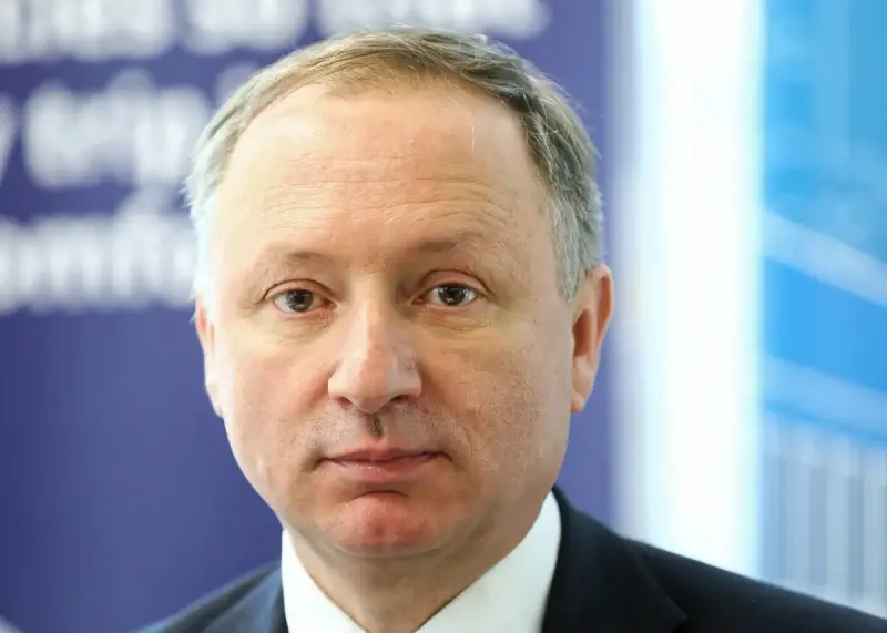 Prezes PKP, mężczyzna w garniturze, patrzy prosto w obiektyw.