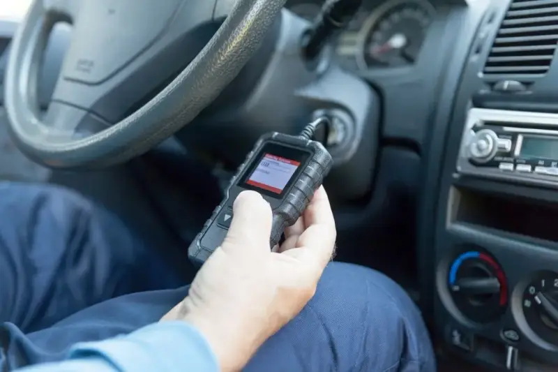 Diagnostyka Opla z kodem DTC U0415. Mechanik sprawdza błędy w samochodzie za pomocą czytnika OBD.