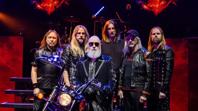 Judas Priest Polska: zespół w skórzanych kurtkach z ćwiekami, z motocyklem na scenie.